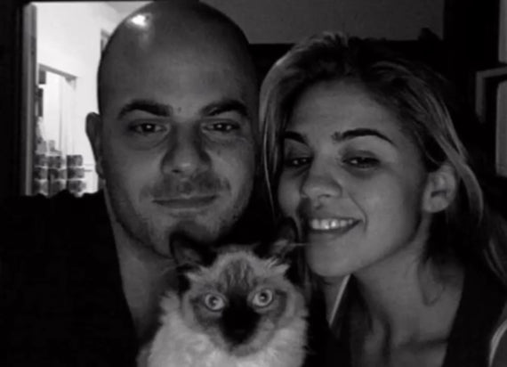 Black and white photo of two smallbatch founders holding their siamese cat.