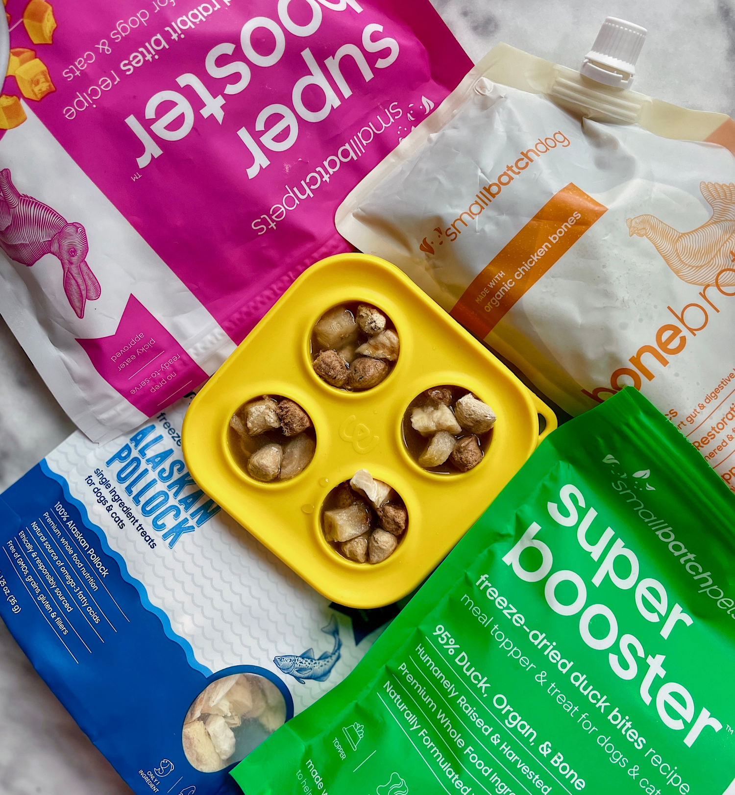 Various smallbatch treat packages in a pile with treat container in the middle. 